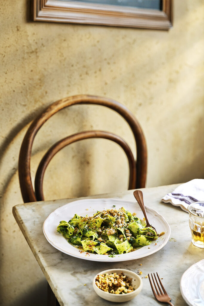 Pappadelle with Pangratatto at the table with chair and picture. Shot by UK Food photographer, stylist and cookbook author Rob Morris using natural daylight from sussex food studio